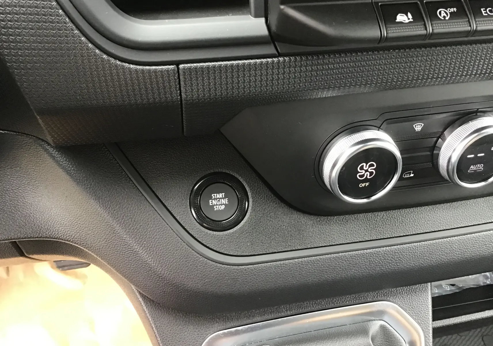 Détail du tableau de bord du Renault Trafic Fourgon noir 2025, avec bouton start/stop et commandes de climatisation.