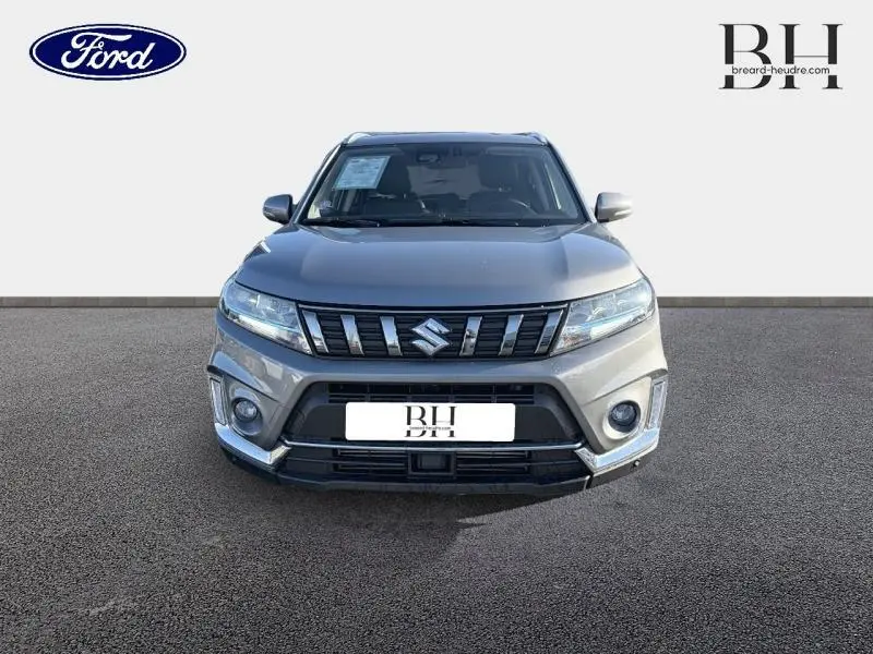 Vue avant d'un Suzuki Vitara Galactic Gray métallisé avec calandre chromée et feux LED distinctifs.