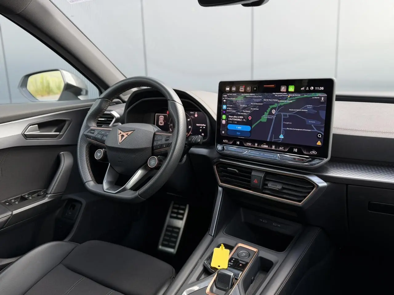 Vue intérieure côté conducteur du CUPRA Formentor 2025, volant cuir noir avec logo cuivre et écran tactile central.