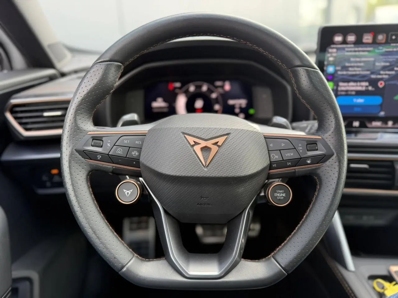 Vue rapprochée du volant cuir noir perforé avec logo CUPRA cuivre et commandes multifonctions du Formentor 2025.