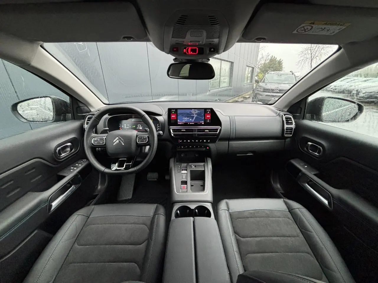 Vue intérieure avant du Citroën C5 Aircross 2025 avec tableau de bord noir et sièges Alcantara Urban Black.
