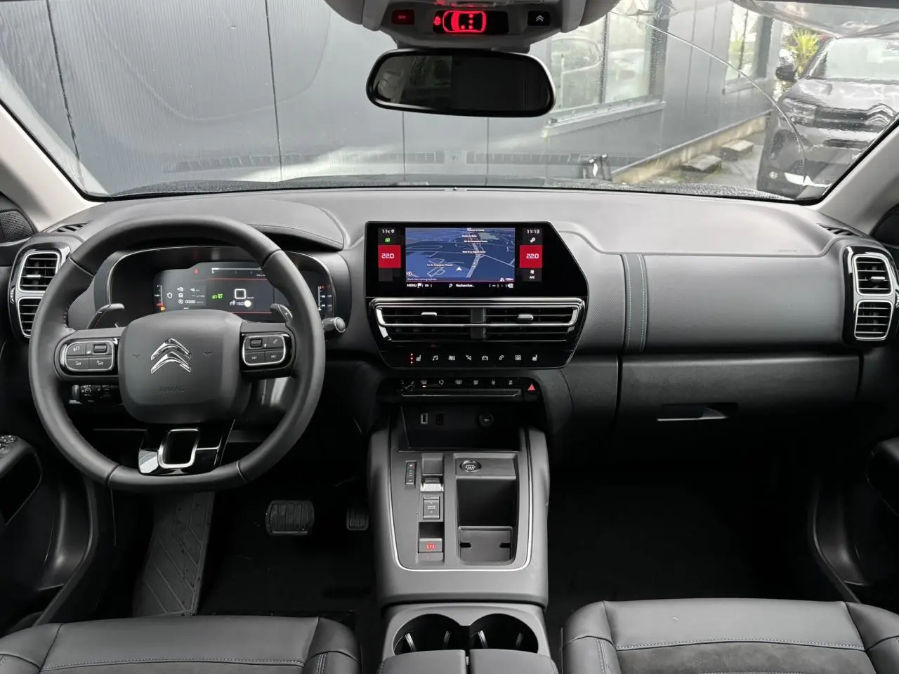 Vue frontale de l’intérieur noir du Citroën C5 Aircross 2025 avec tableau de bord numérique et écran tactile central.