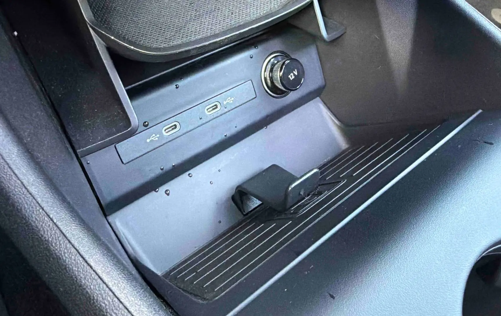 Gros plan sur la console centrale noire de l'Audi Q4 e-tron 45 avec ports USB-C et prise 12V visibles.