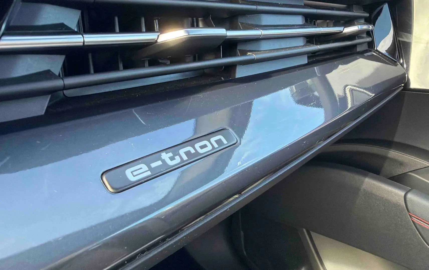 Détail intérieur du tableau de bord gris galet avec logo e-tron sur Audi Q4 e-tron 2025.