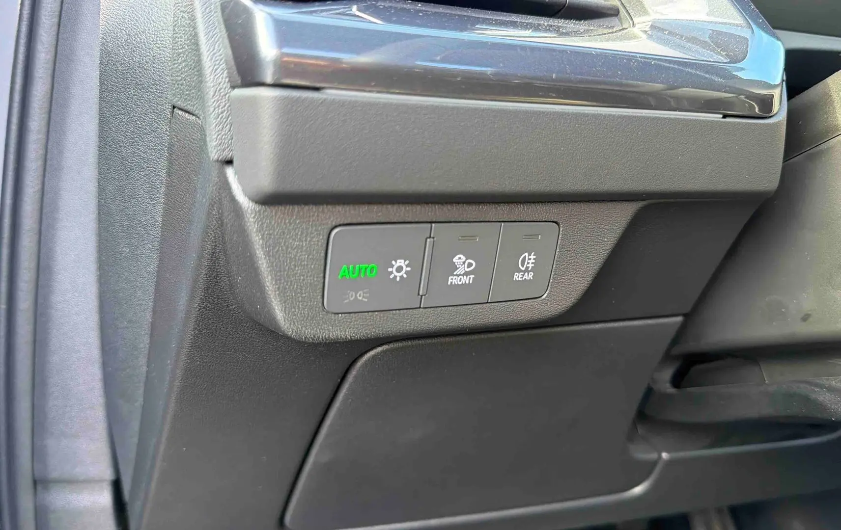 Détail des commandes d'éclairage côté gauche du tableau de bord d'un Audi Q4 e-tron gris galet 2025.