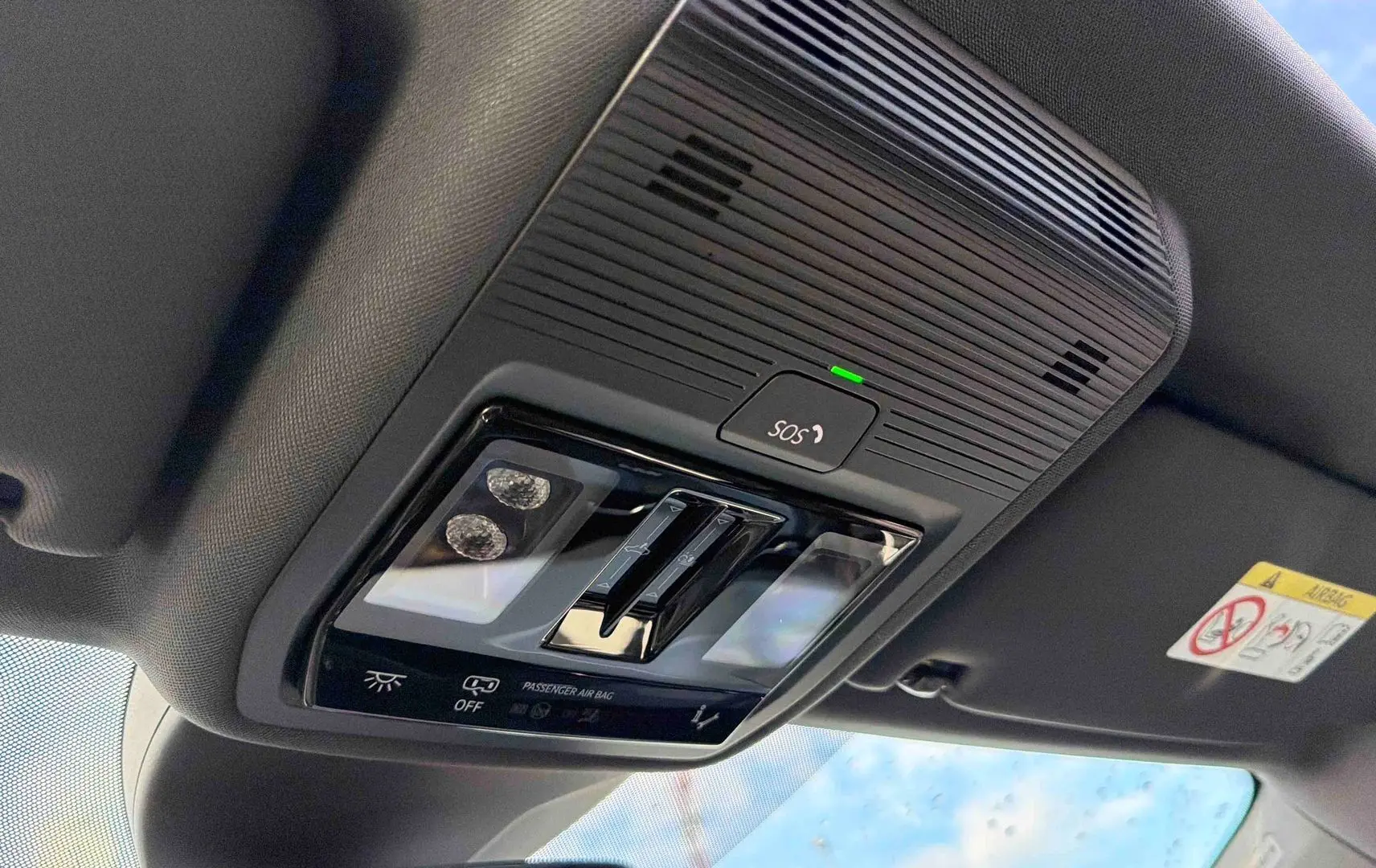 Vue intérieure en plongée du plafonnier gris avec bouton SOS et éclairages LED de l'Audi Q4 e-tron 2025.