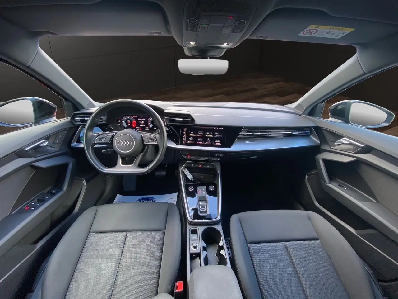 Intérieur noir de l'Audi A3 Sportback 2021, vue avant sur le tableau de bord, volant multifonction et console centrale moderne.