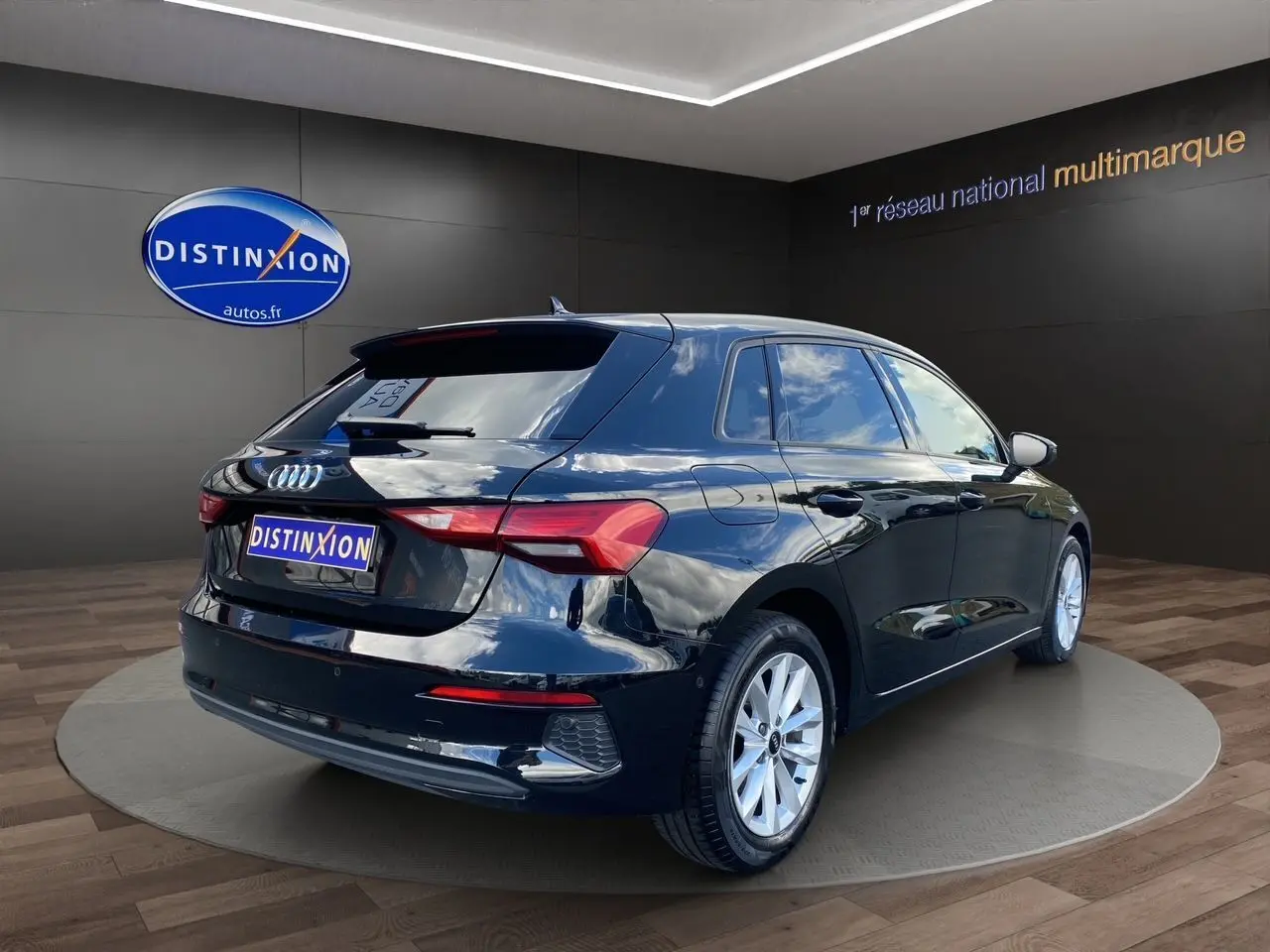 Audi A3 Sportback noir vue 3/4 arrière droit, avec jantes argentées et caméra de recul visible sur le hayon.