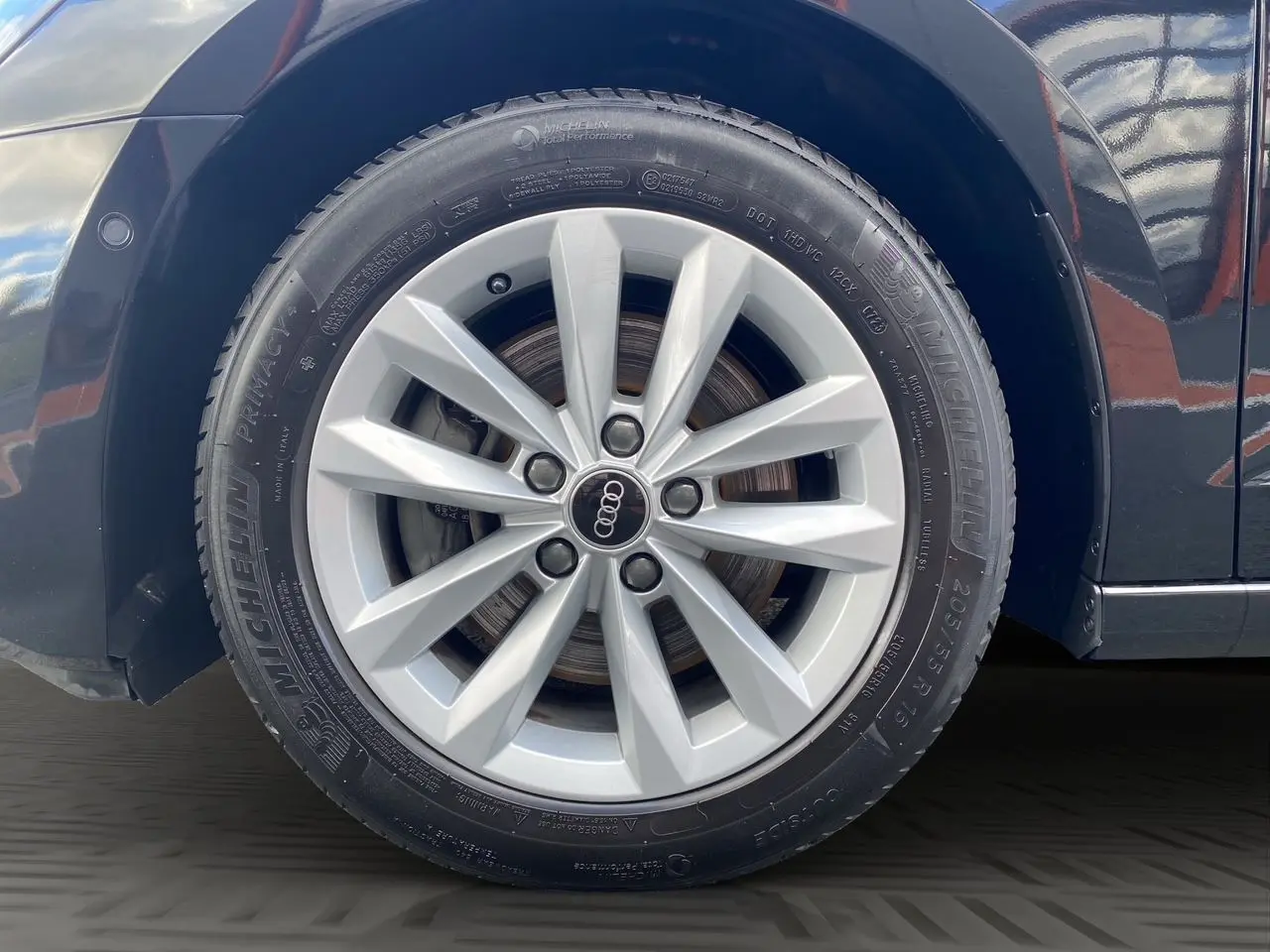 Gros plan sur la roue avant droite de l'Audi A3 Sportback noire, mettant en valeur la jante en alliage et le pneu Michelin.