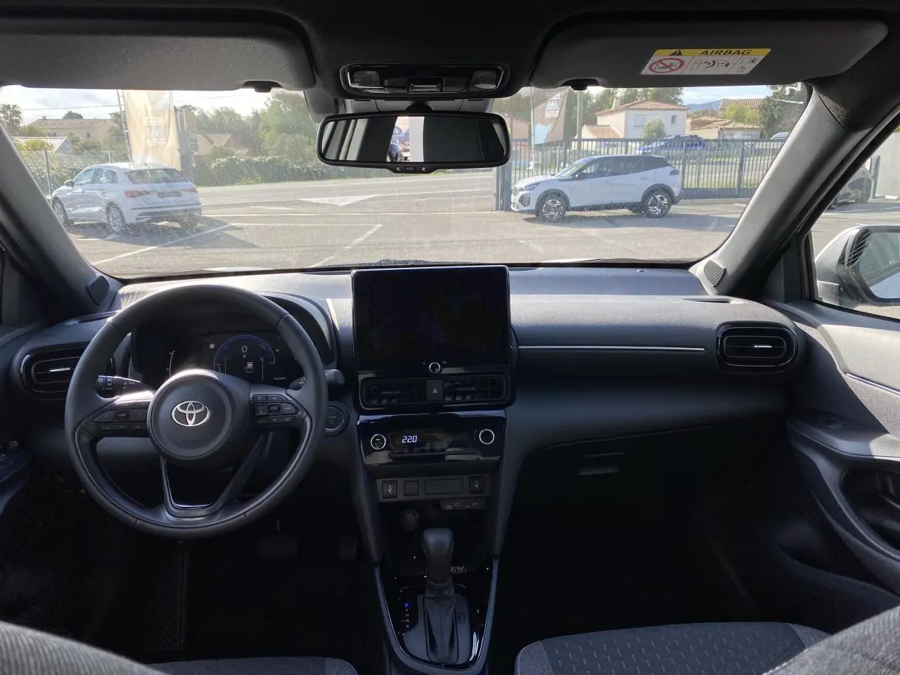 Vue intérieure du tableau de bord et volant cuir noir de la Toyota Yaris Cross 2025 avec écran tactile central.