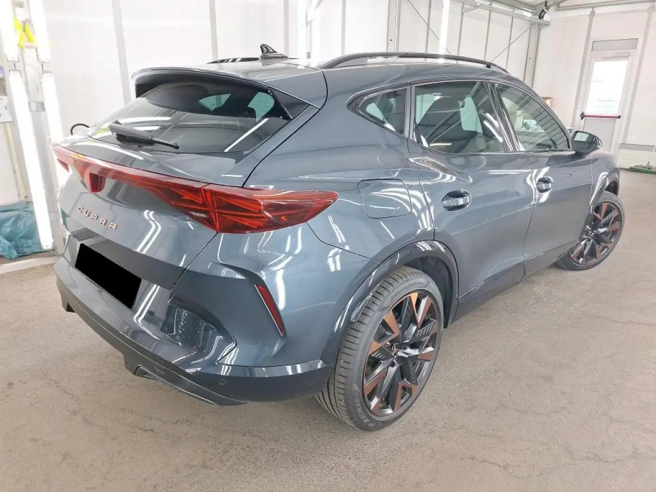 Vue 3/4 arrière droite du CUPRA Formentor 2024 gris magnétique avec jantes alliage 19'' cuivrées et hayon électrique.