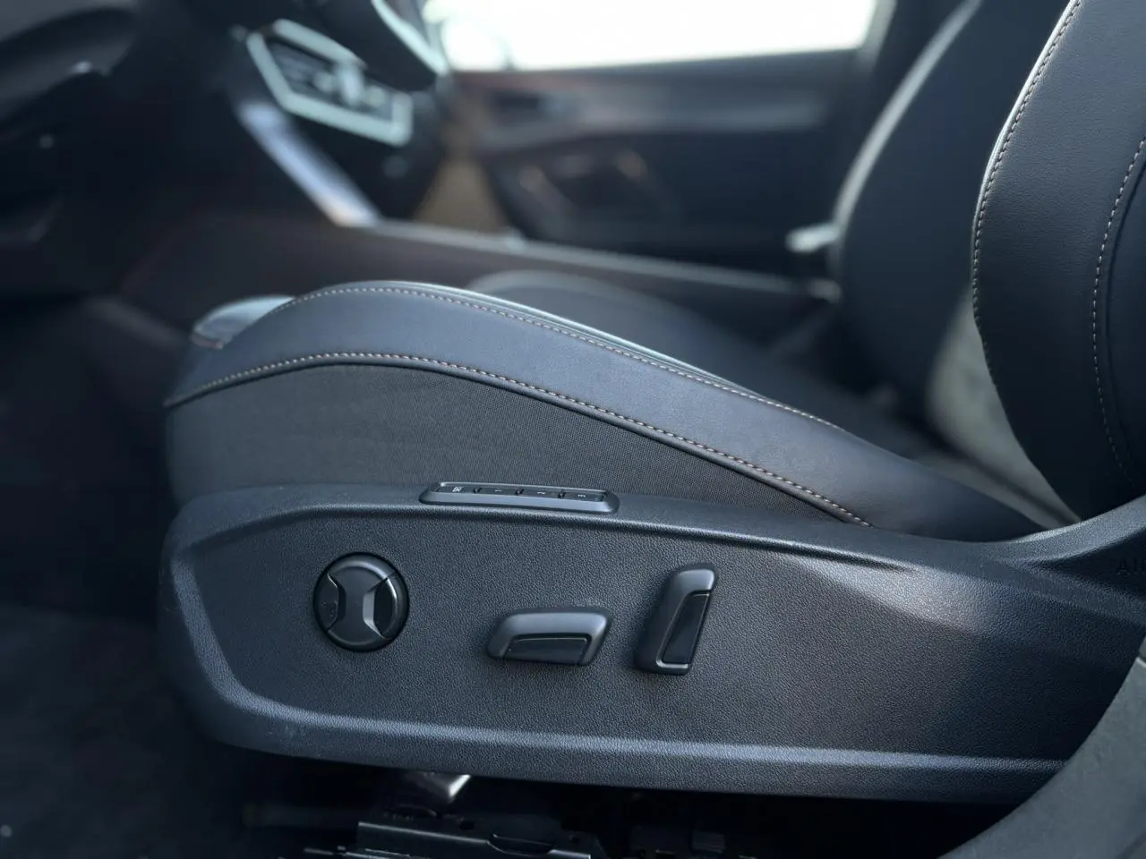 Gros plan sur les commandes de réglage électrique du siège conducteur noir suédine du CUPRA Formentor 2024.