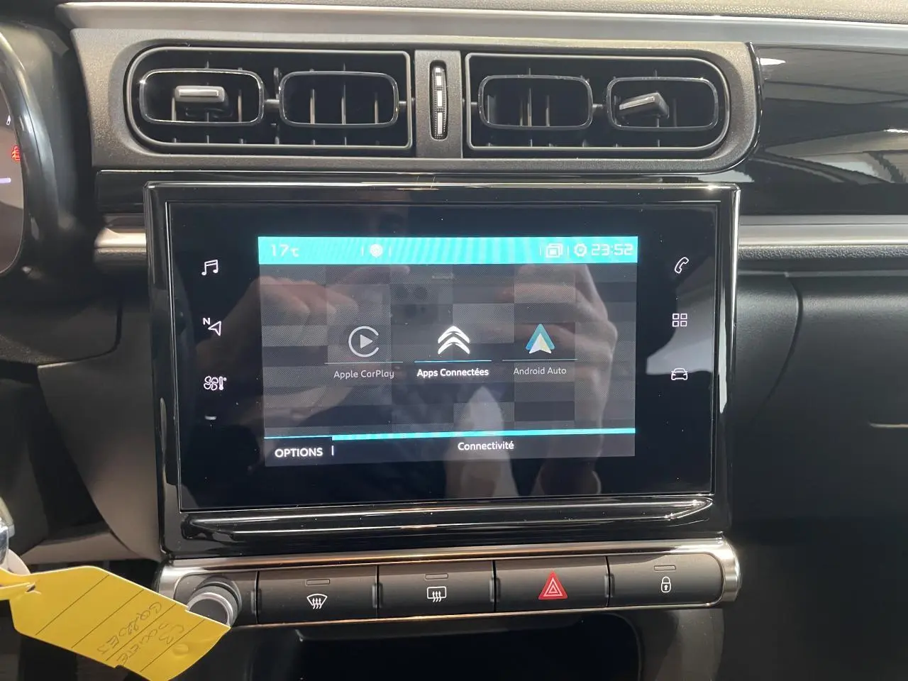 Vue rapprochée de la console centrale noire brillante avec écran tactile affichant Apple CarPlay et Android Auto sur Citroën C3 2023.