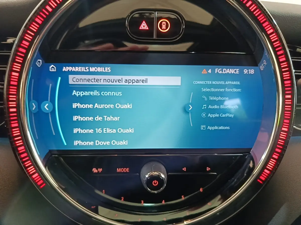 Écran tactile central circulaire de MINI Cooper noir 2023 avec interface connectivité mobile et anneau lumineux rouge.