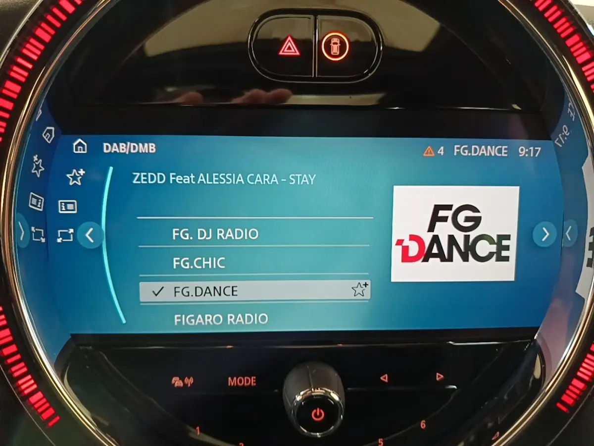 Écran central tactile de la MINI Cooper Edition Premium Plus noir, affichant la radio FG.DANCE avec éclairage LED rouge circulaire.