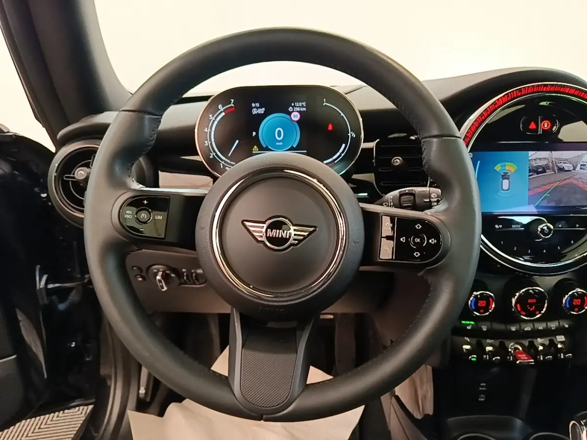 Vue intérieure centrée sur le volant cuir noir et le combiné d'instruments digital d'une MINI Cooper 2023.