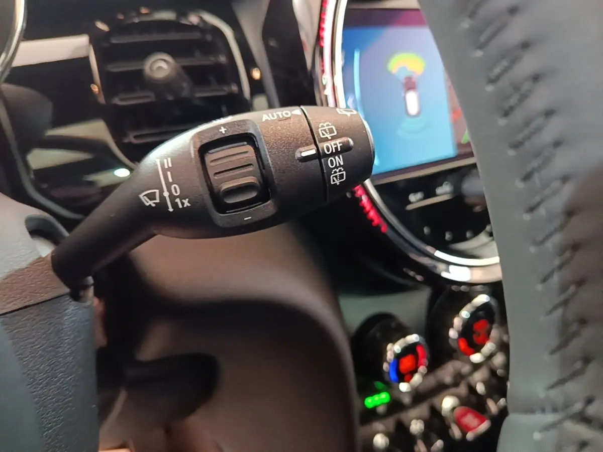 Gros plan sur la commande d’essuie-glace à gauche du volant dans l’habitacle noir d’une MINI Cooper 2023.