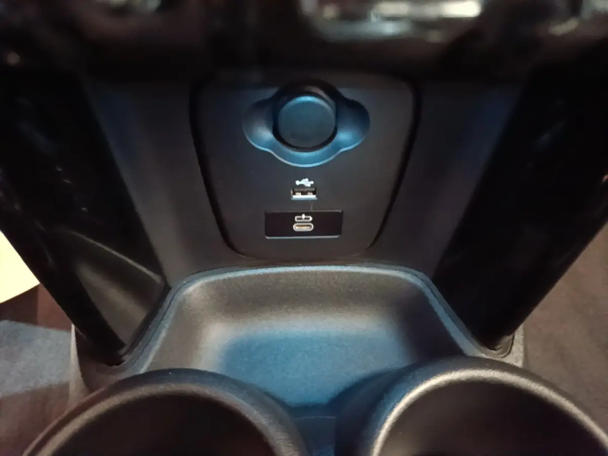 Vue rapprochée de la console centrale noire de la MINI Cooper Edition Premium Plus avec ports USB et prise 12V.