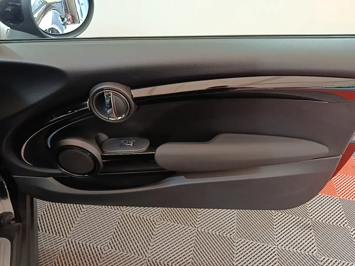 Vue intérieure côté gauche de la porte noire d'une MINI Cooper Edition Premium Plus 2023 avec commande de vitre et haut-parleur intégré.