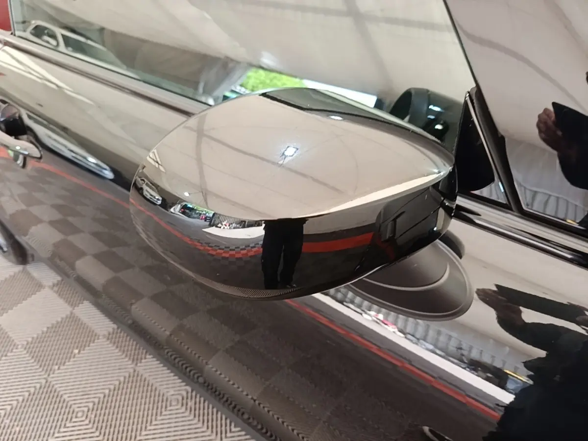 Gros plan sur le rétroviseur côté gauche noir brillant d'une MINI Cooper Edition Premium Plus 2023.