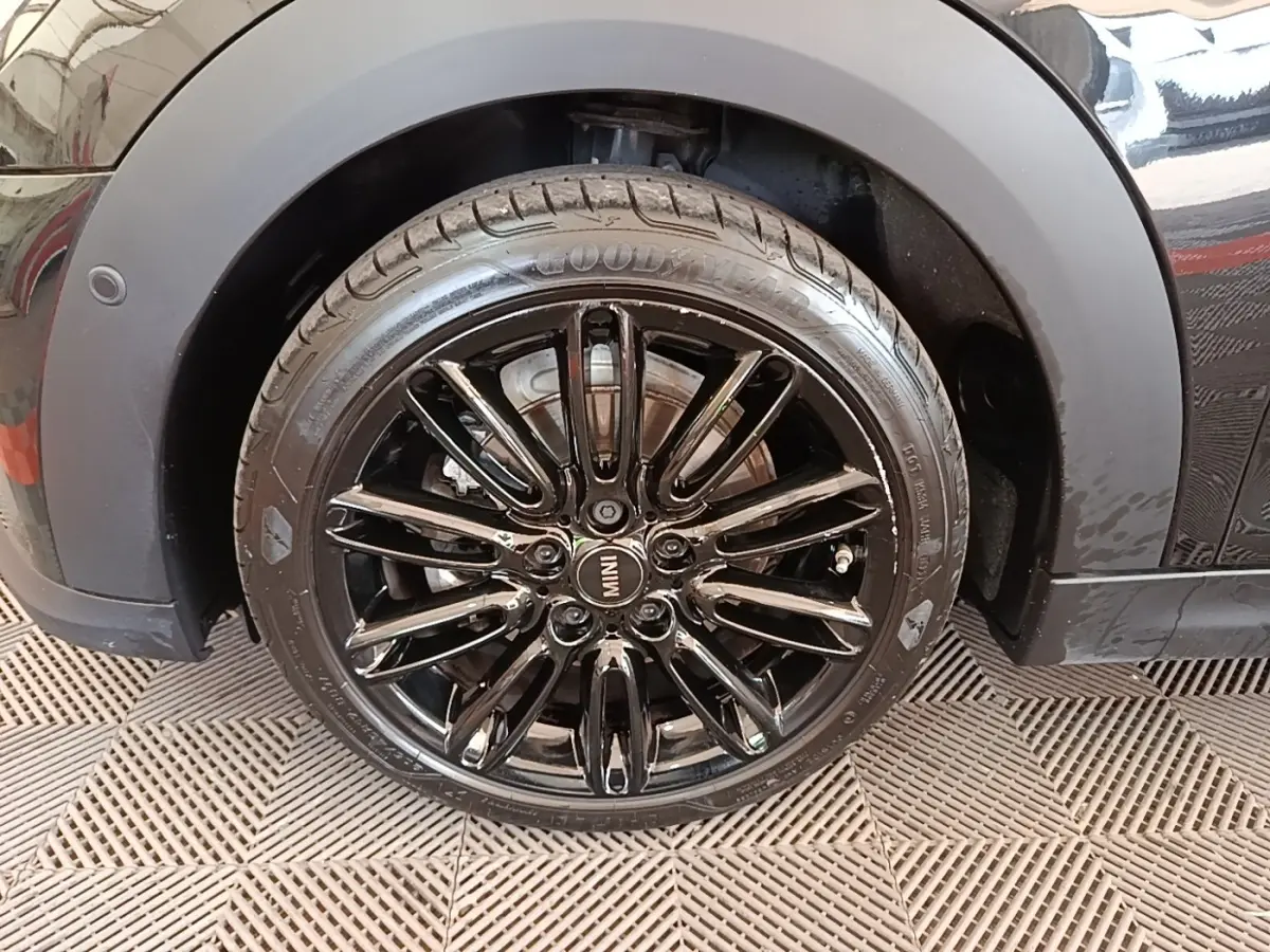 Gros plan sur la roue avant droite noire brillante d'une MINI Cooper Edition Premium Plus 2023 avec jante noire multi-branches.