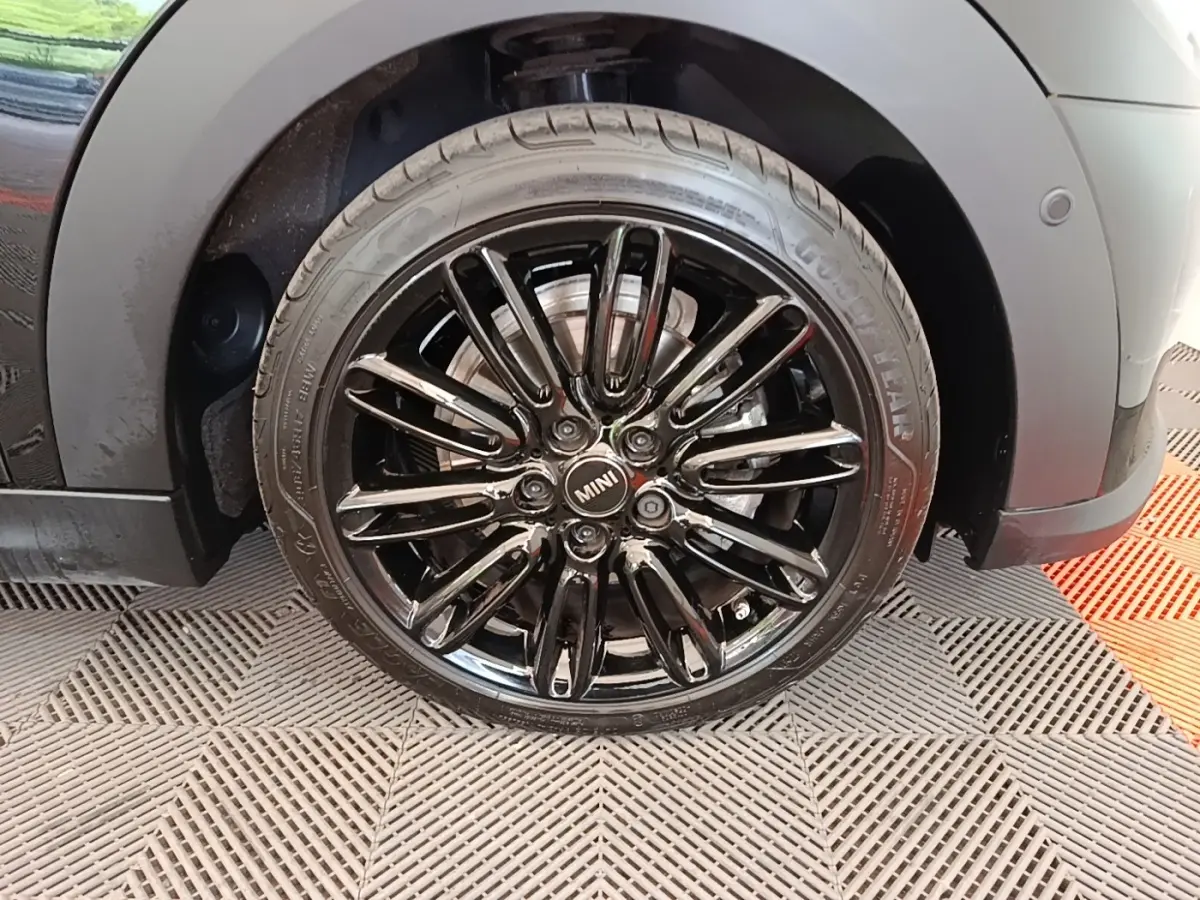 Gros plan sur la roue avant gauche noire brillante d'une MINI Cooper Edition Premium Plus 2023, jante multi-branches.