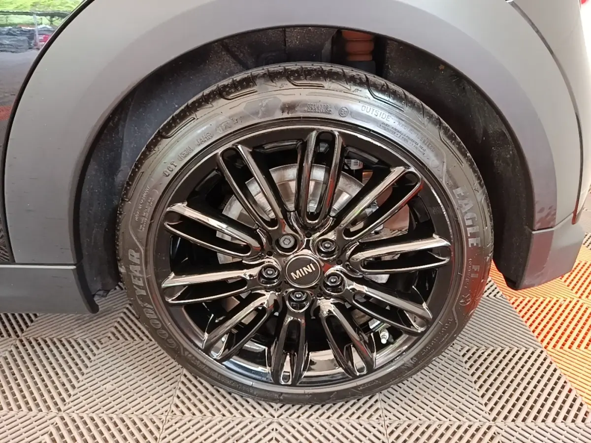 Gros plan sur la roue avant droite noire brillante d'une MINI Cooper Edition Premium Plus 2023.