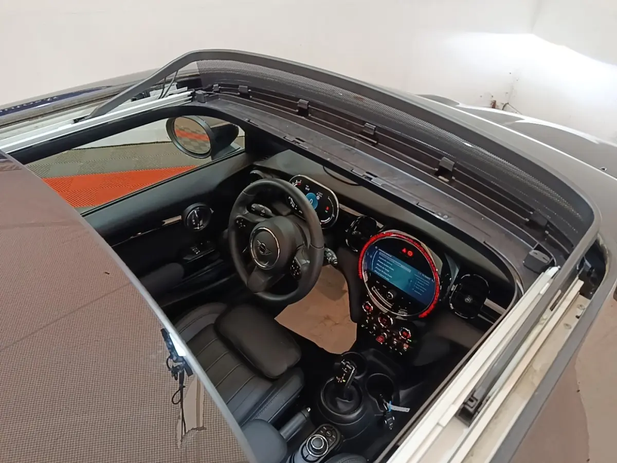 Vue intérieure plongeante du poste de conduite noir d'une MINI Cooper Edition Premium Plus 2023 avec toit ouvrant en verre.