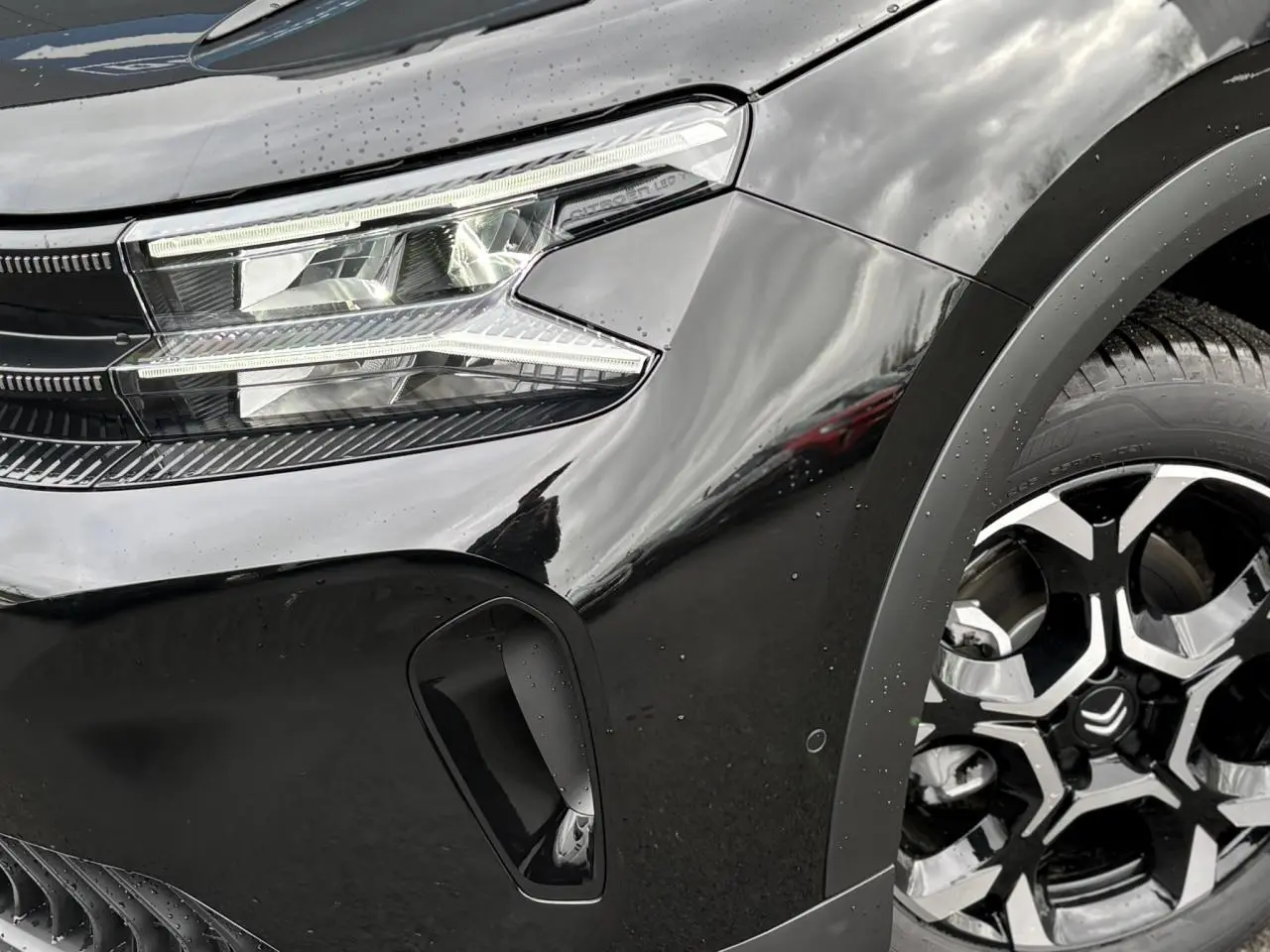 Gros plan sur l'avant droit noir Perla du Citroën C5 Aircross 2025 avec phare LED et jante alliage bi-ton.