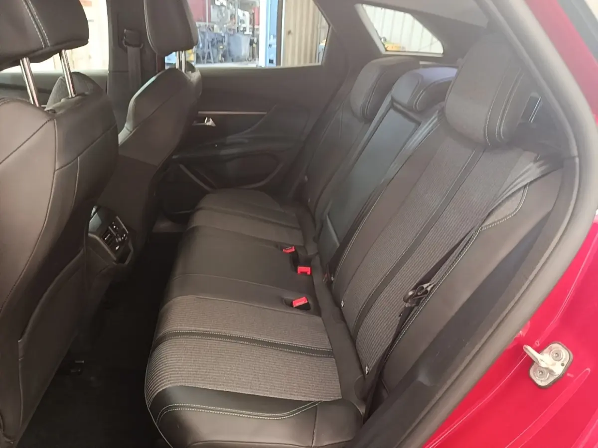 Vue intérieure côté droit des sièges arrière noirs et gris du Peugeot 3008 PureTech 130 S&S Allure 2021, porte rouge ouverte.