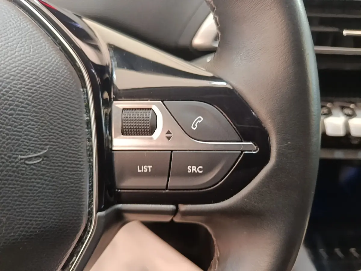 Gros plan sur les commandes gauche du volant cuir noir du Peugeot 3008 PureTech 130 S&S Allure 2021.