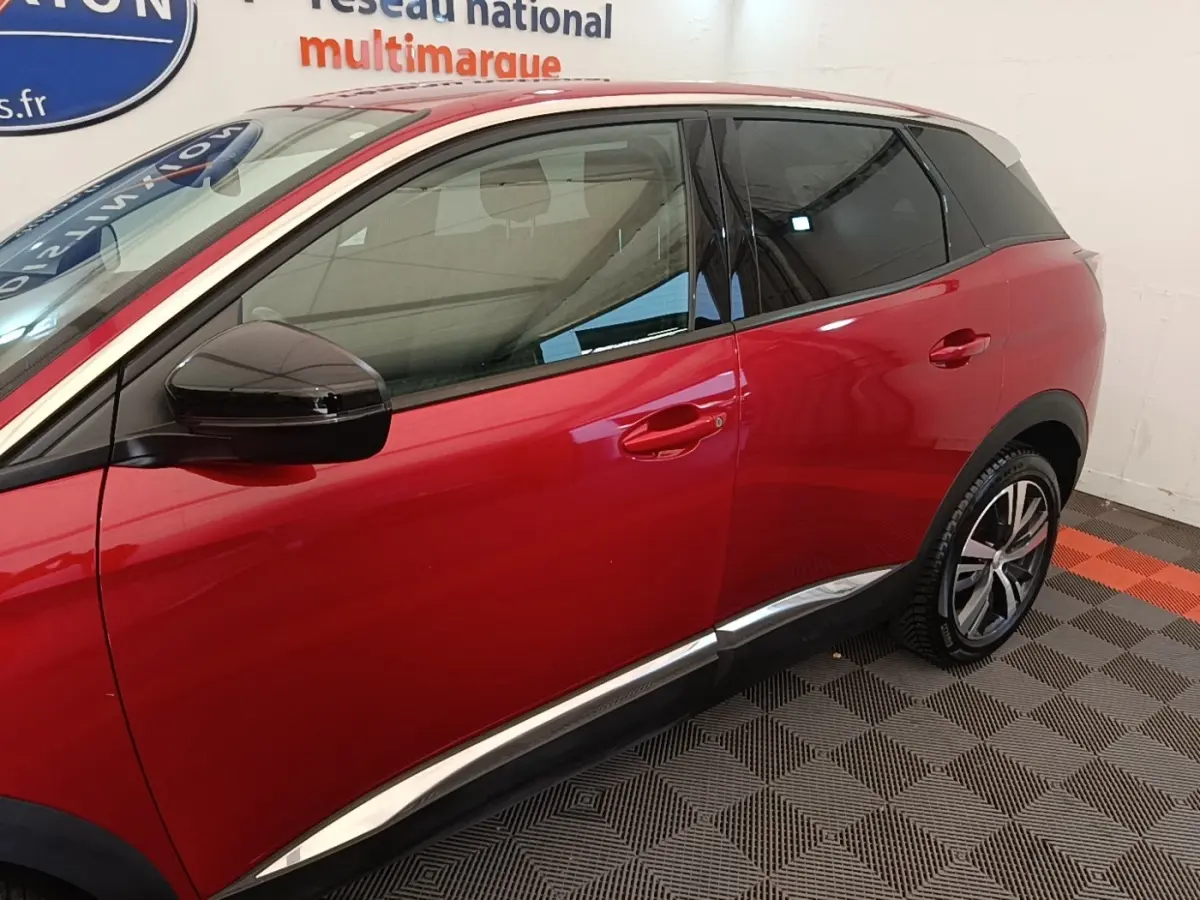 Vue latérale droite du Peugeot 3008 rouge avec toit blanc et rétroviseur noir brillant dans un showroom.