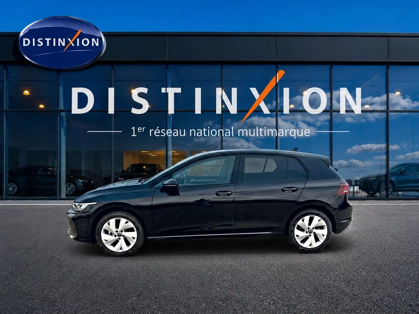 Profil droit d'une Volkswagen Golf noire 2026 garée devant une vitrine avec logo Distinxion.