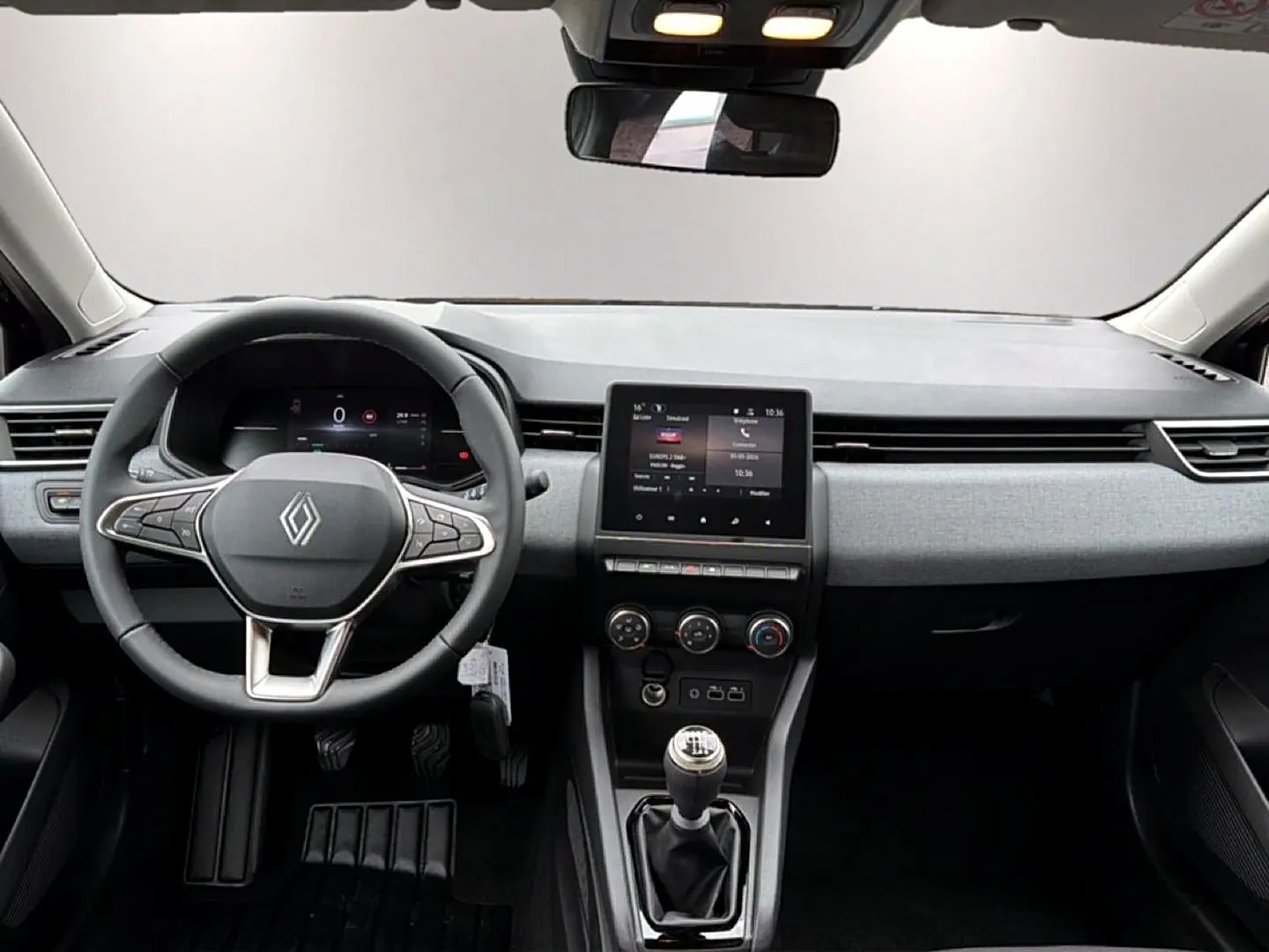 Vue intérieure avant de la Renault Clio V noire, montrant le volant multifonction et la console centrale avec écran tactile.