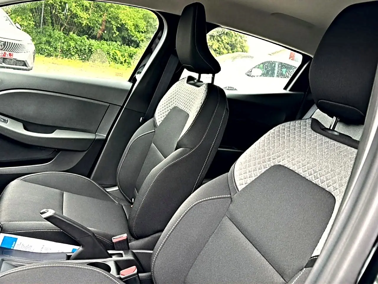 Vue intérieure côté droit des sièges avant tissu noir et gris clair de la Renault Clio V 2026.