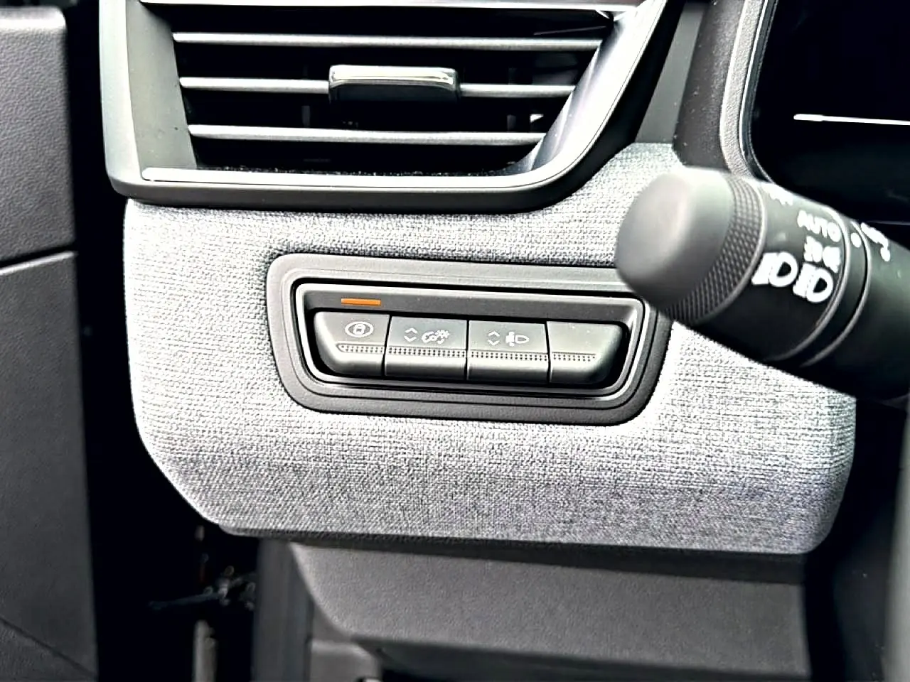 Détail intérieur côté gauche de la planche de bord de Renault Clio V noir, avec commandes d’éclairage et ventilation.