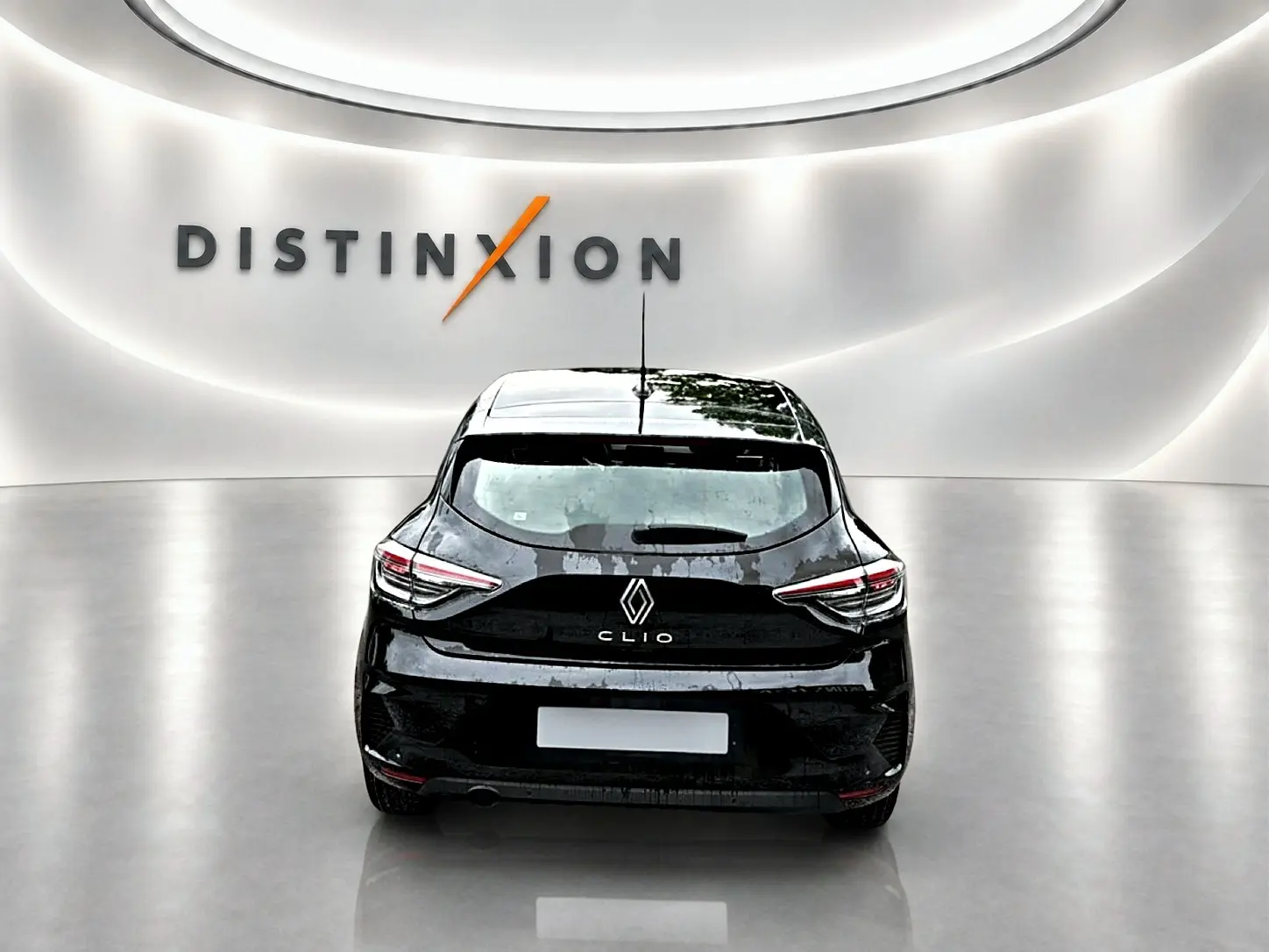 Vue arrière d'une Renault Clio V noire dans un studio lumineux avec logo Distinxion en arrière-plan.