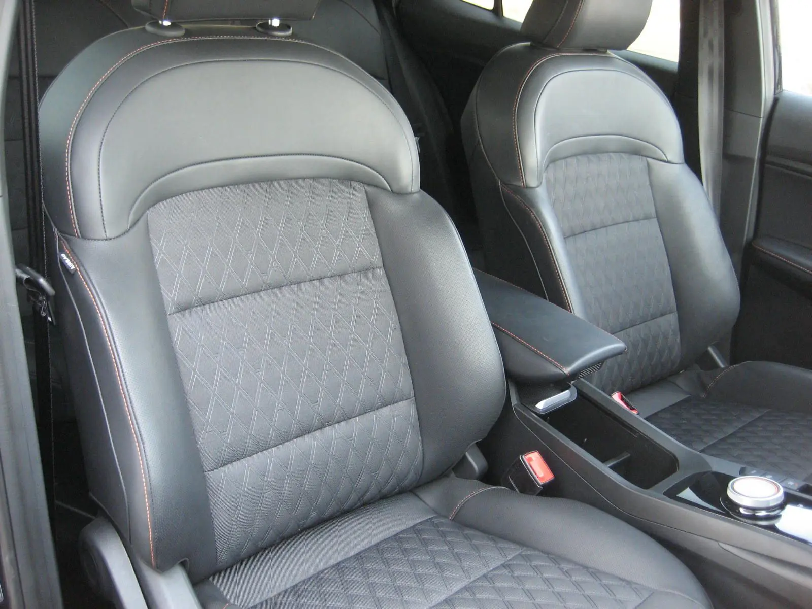 Gros plan sur les sièges avant en cuir noir avec surpiqûres orange de la MG3 1.5 HYBRID+ 2024.