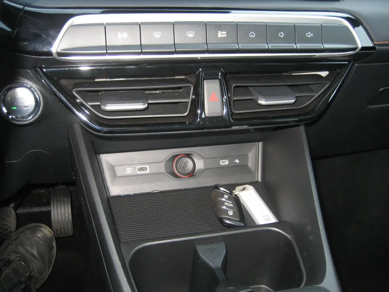 Vue rapprochée de la console centrale noire du MG3 2024 avec boutons de commande, prise 12V et clé posée.