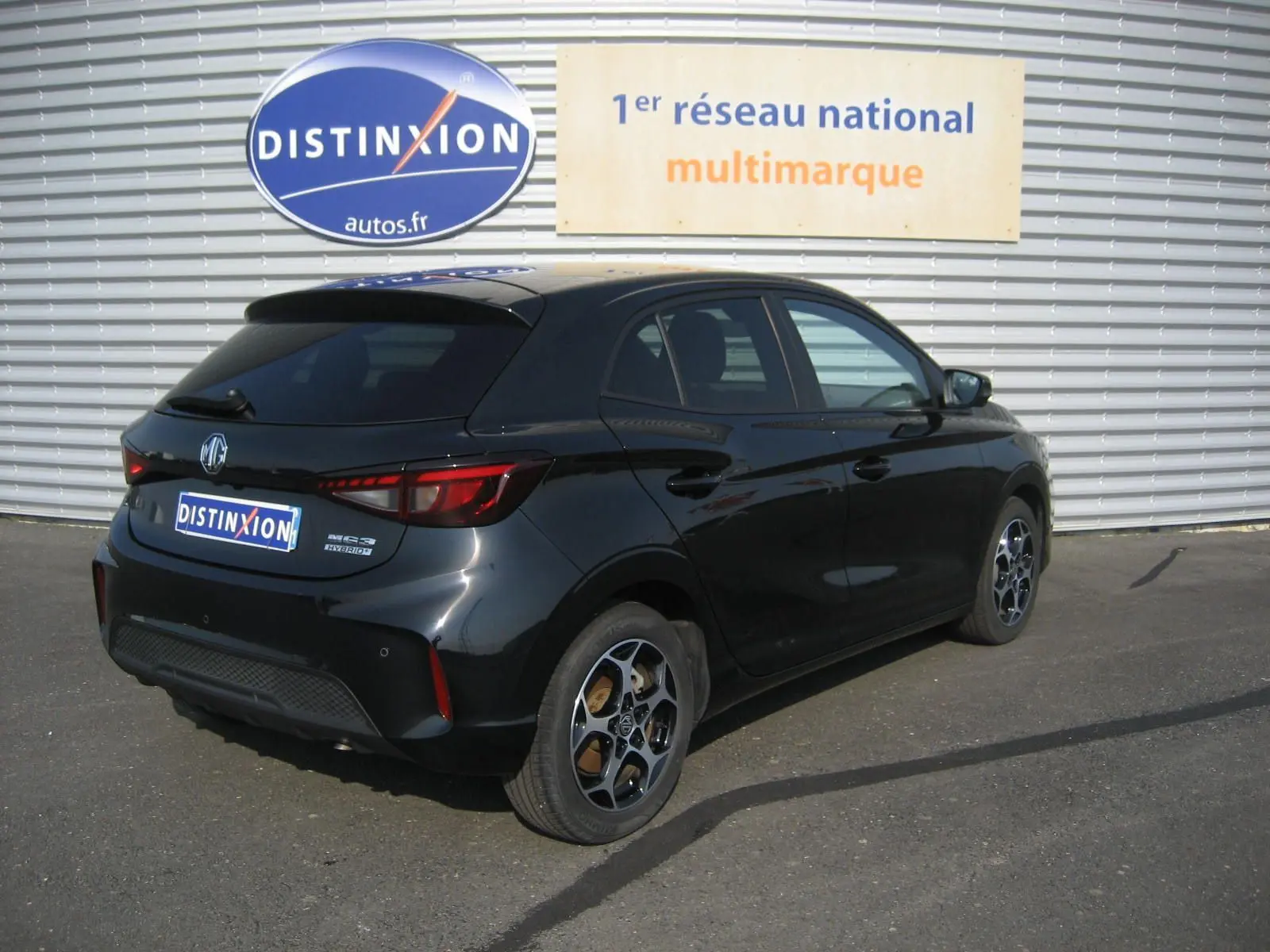 Vue 3/4 arrière droite d'une MG3 noire 2024 hybride avec jantes alliage et feux arrière LED distinctifs.