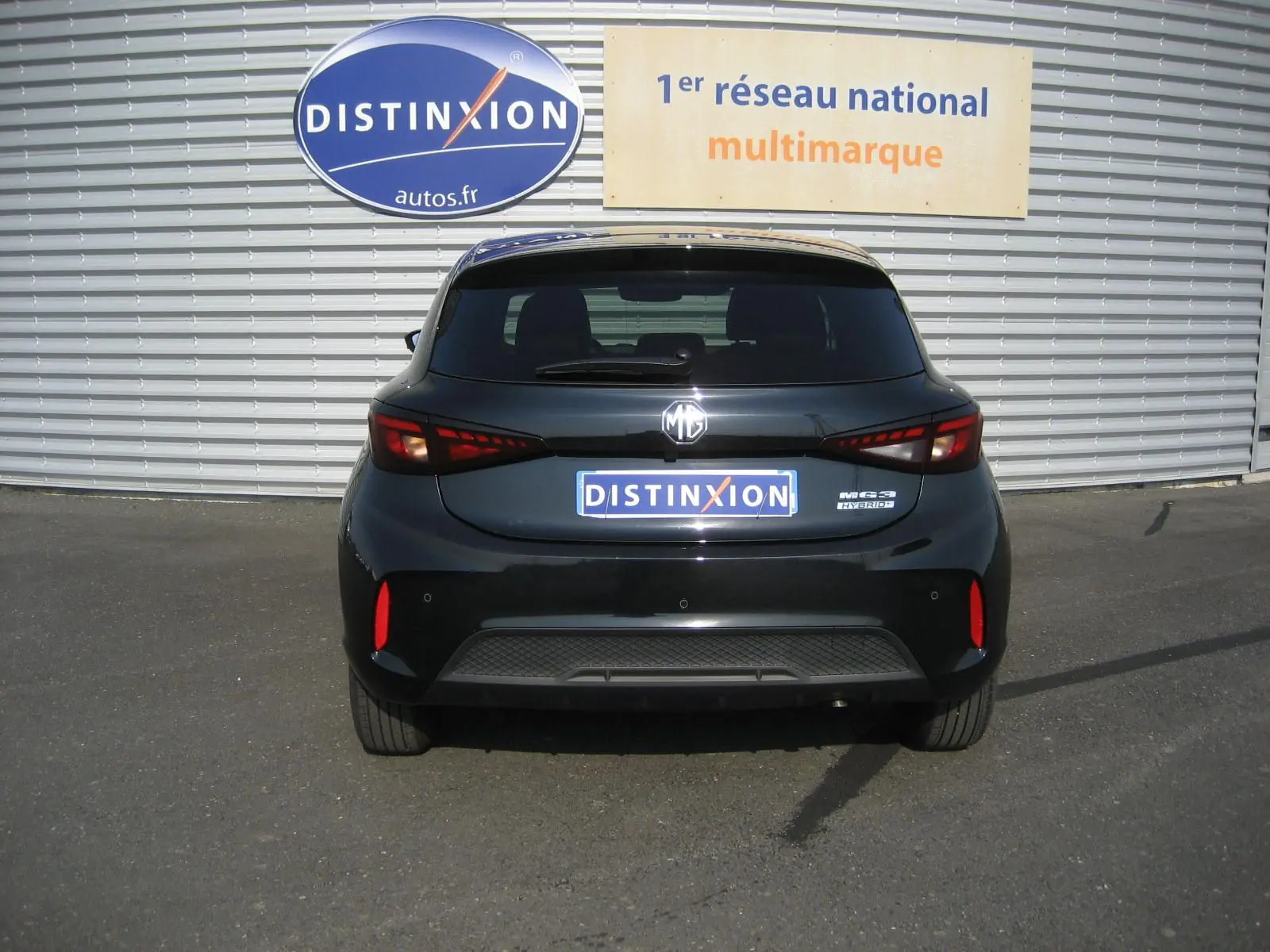 Vue arrière d'une MG3 noire 2024 hybride, avec feux arrière LED et logo MG bien visible sur un parking.