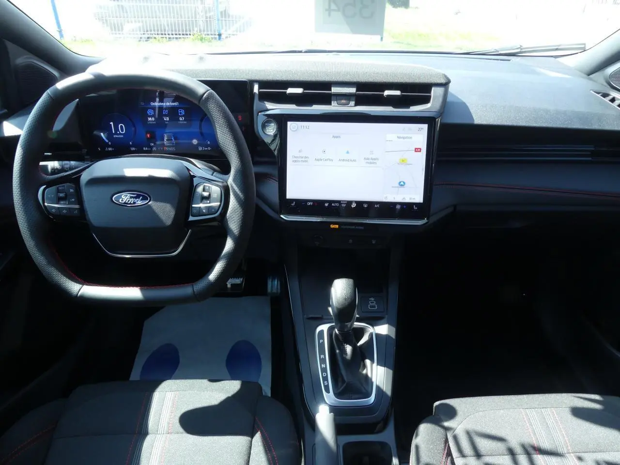 Intérieur du Ford Puma 2025 vu de face, tableau de bord moderne avec écran tactile et volant multifonction noir.