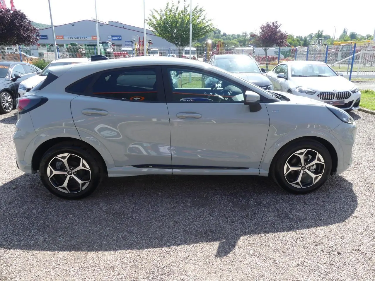 Ford Puma 2025 gris métallisé en vue profil côté gauche, avec jantes alliage 17 pouces et vitres arrière surteintées.