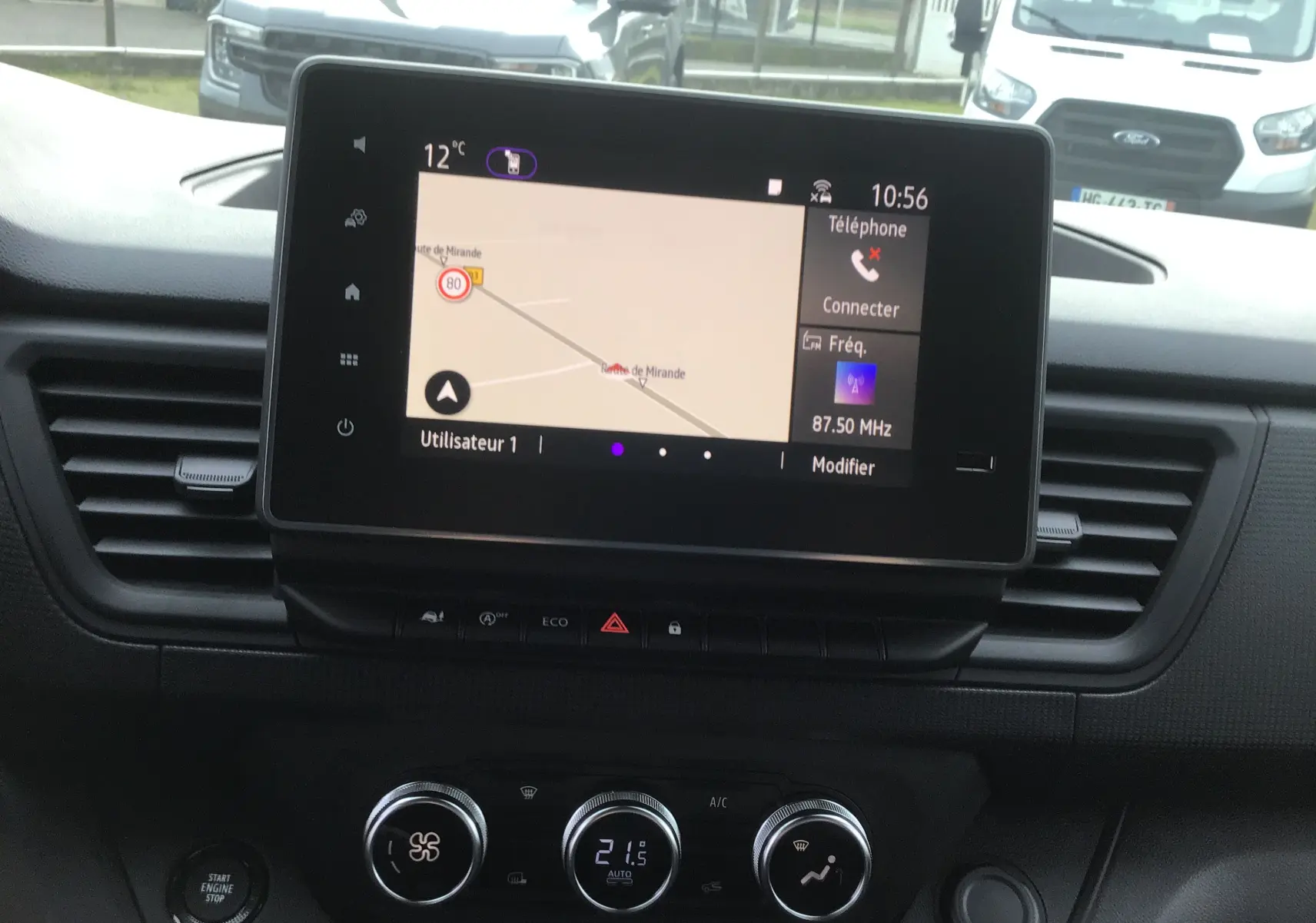 Vue intérieure du tableau de bord du Renault Trafic Fourgon 2025 avec écran tactile affichant la navigation et commandes de climatisation.