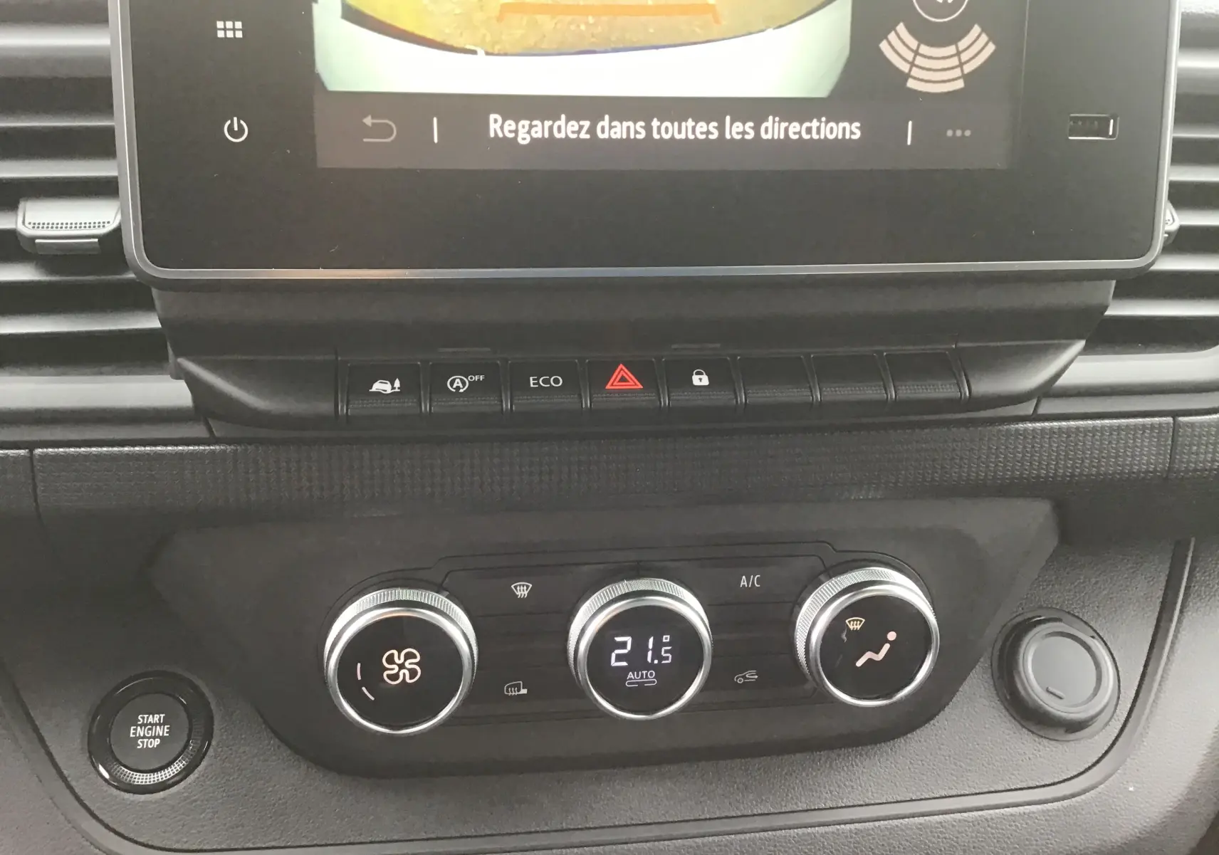 Détail du tableau de bord du Renault Trafic Fourgon L1H1 2025 montrant les commandes de climatisation et le bouton start/stop.