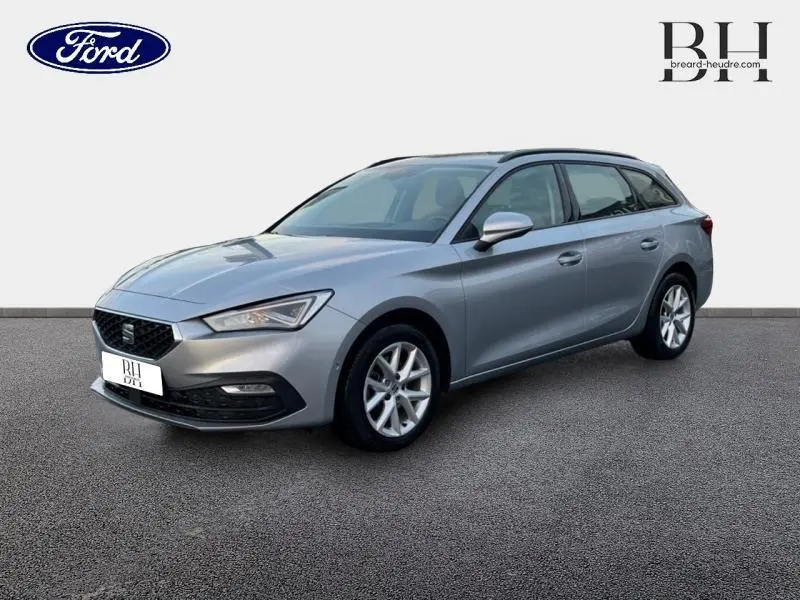 SEAT LEON ST gris urbain métal vue 3/4 avant droit, jantes alu et barres de toit visibles sur fond neutre.