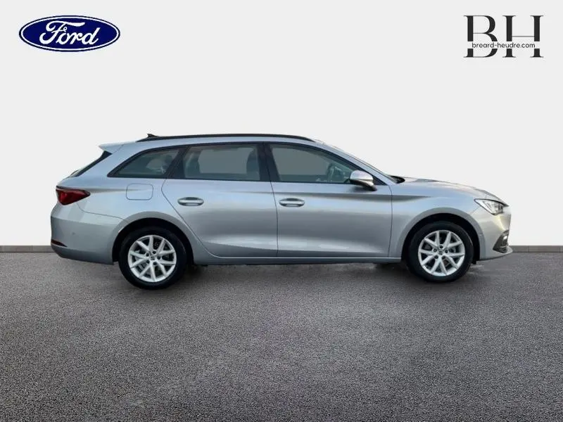 Profil droit d'une SEAT LEON ST 1.0 eTSI 110ch Urban DSG7 gris urbain métal, break compact aux lignes fluides et jantes alu.