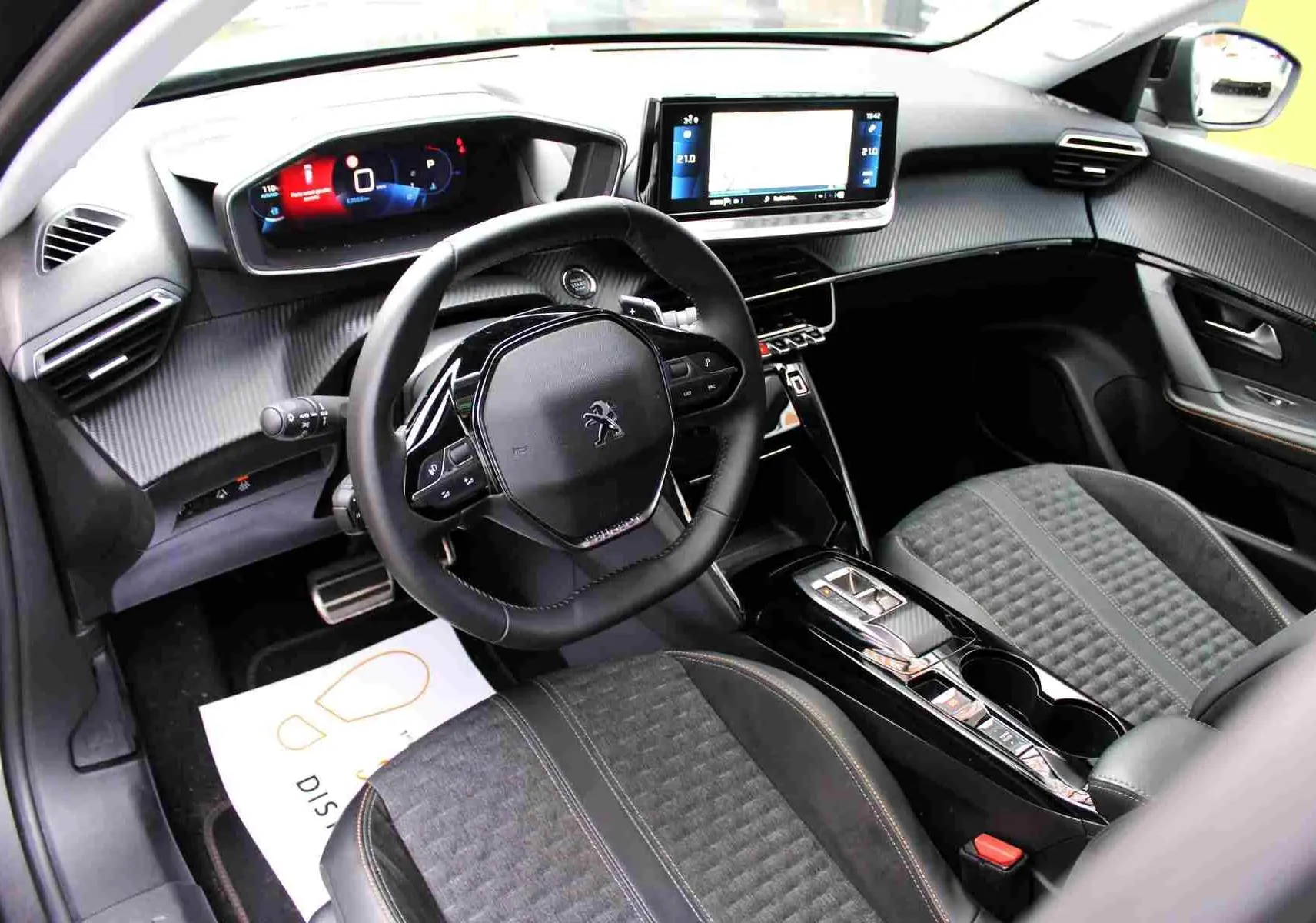 Intérieur du Peugeot 2008 II 1.2 PureTech 130 ch Roadtrip, vue côté conducteur sur tableau de bord et sièges noirs.