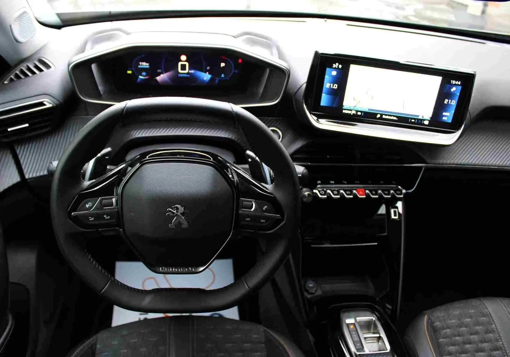 Vue intérieure du tableau de bord et volant du Peugeot 2008 gris platinium avec écran tactile et commandes au volant.