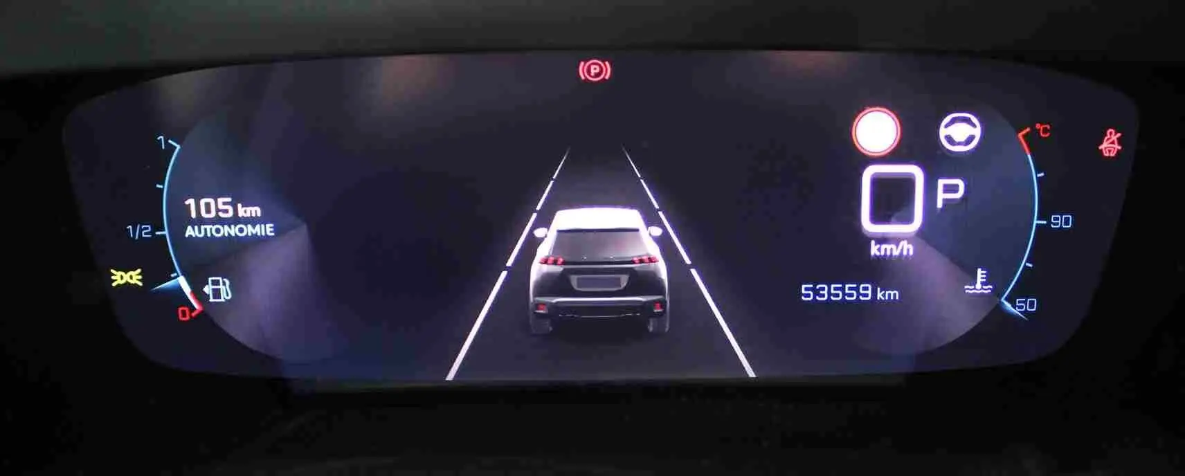 Affichage numérique du tableau de bord du Peugeot 2008 gris platinium, montrant une vue arrière stylisée du véhicule en stationnement.